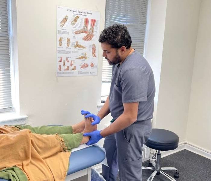 Dr. Sadi Alam examining a patient's foot and ankle.